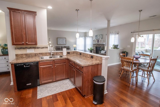 kitchen featuring a peninsula, a fireplace, black dishwasher, a sink, and open floor plan