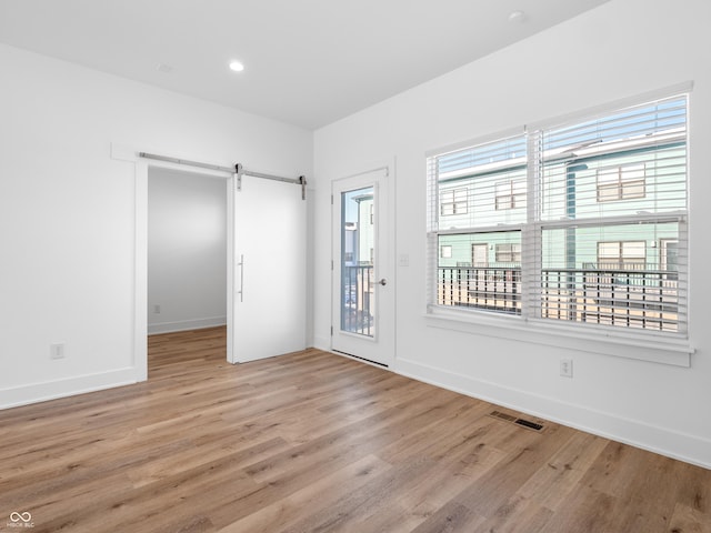 2578 Filson St, Carmel, IN 46032 - unfurnished room with baseboards, visible vents, a barn door, and light wood finished floors
