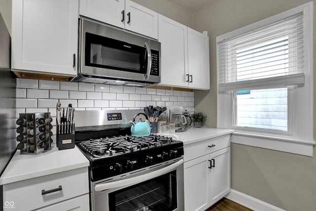 112 S Spencer Ave, Indianapolis, IN 46219 - kitchen featuring white cabinetry, light countertops, stainless steel appliances, and decorative backsplash