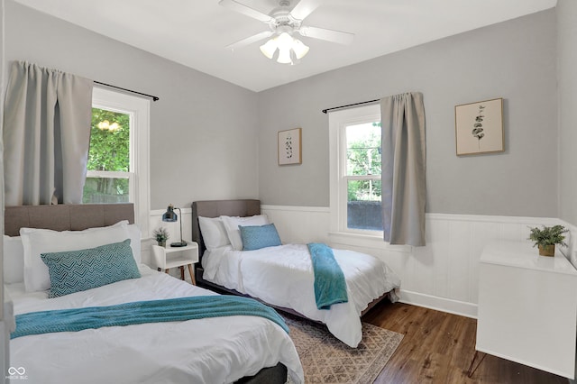 112 S Spencer Ave, Indianapolis, IN 46219 - bedroom with wood finished floors, multiple windows, ceiling fan, and wainscoting