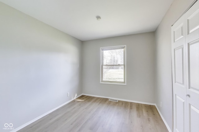 7906 E 21st St, Indianapolis, IN 46219 - unfurnished bedroom with light wood-style flooring, baseboards, and visible vents