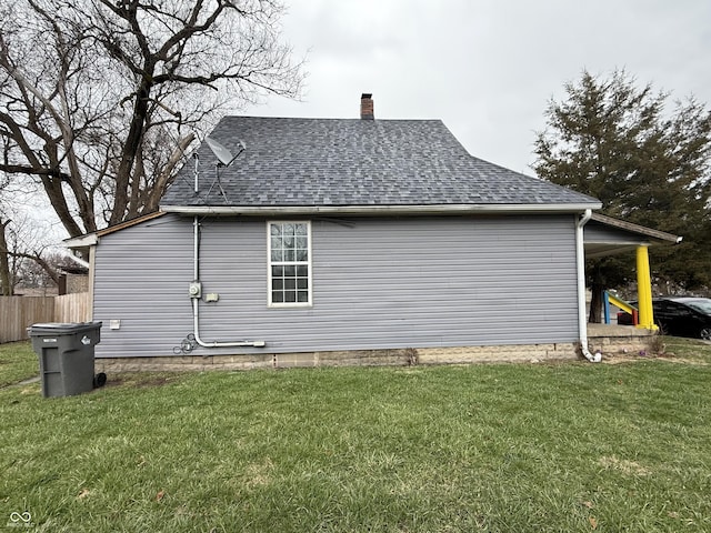 view of property exterior with a chimney, a shingled roof, fence, and a yard