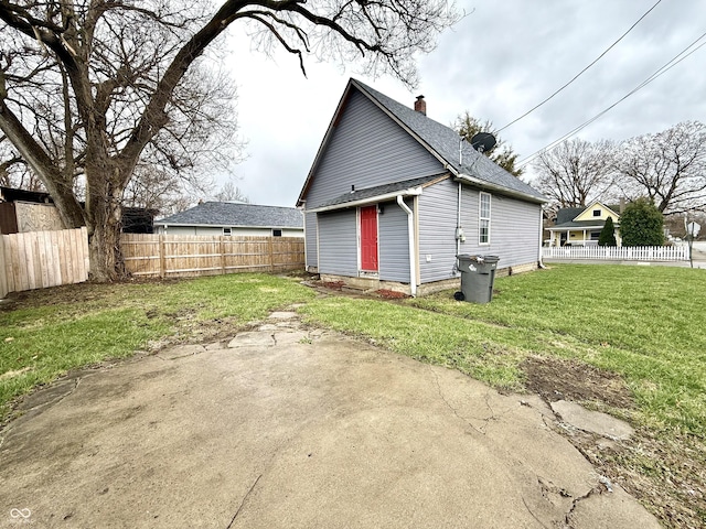 rear view of property with a lawn, a chimney, a patio area, and fence private yard
