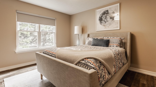 bedroom with baseboards and wood finished floors