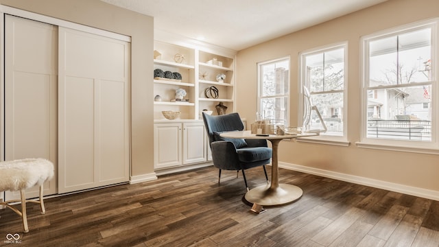 sitting room with dark wood-type flooring and baseboards
