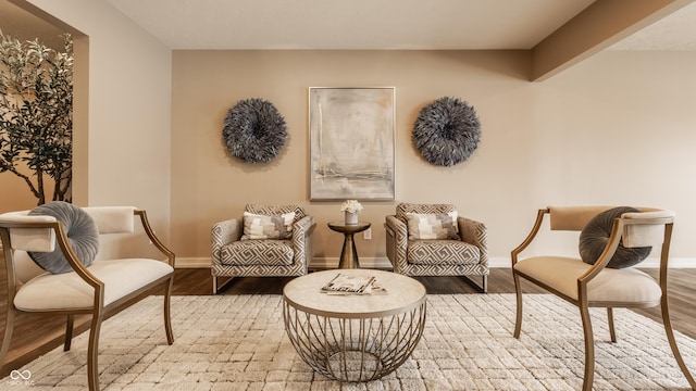 sitting room with baseboards and wood finished floors