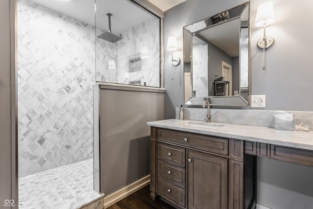 bathroom featuring wood finished floors, vanity, and walk in shower