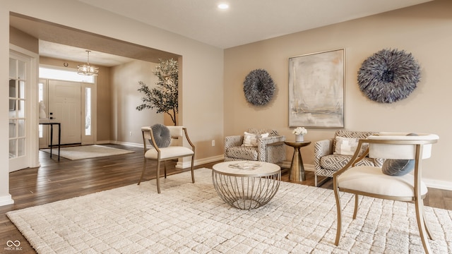 living area with baseboards, wood finished floors, and recessed lighting