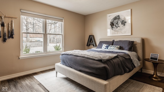 bedroom featuring baseboards and wood finished floors