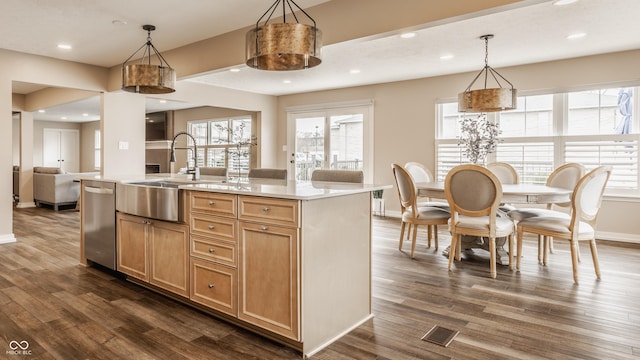 kitchen with light countertops, a sink, stainless steel dishwasher, visible vents, and dark wood-type flooring