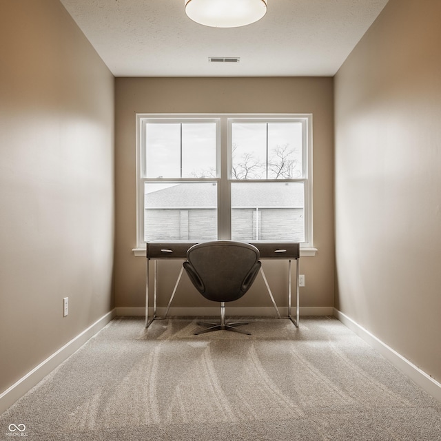 unfurnished office with baseboards, carpet floors, and visible vents