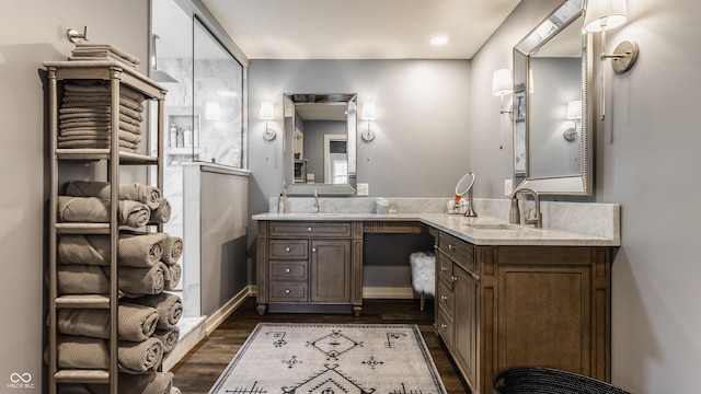 full bathroom with double vanity, wood finished floors, and a sink