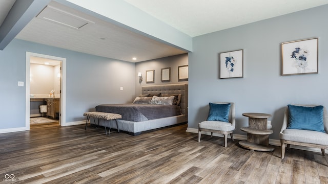 bedroom with attic access, ensuite bathroom, baseboards, and wood finished floors