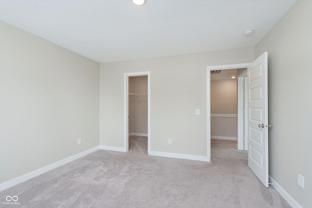 1239 Newton St, Avon, IN 46123 - unfurnished bedroom featuring a closet, recessed lighting, baseboards, a walk in closet, and light carpet