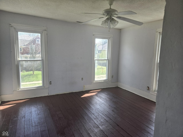 unfurnished room featuring a textured ceiling, ceiling fan, hardwood / wood-style flooring, and a healthy amount of sunlight