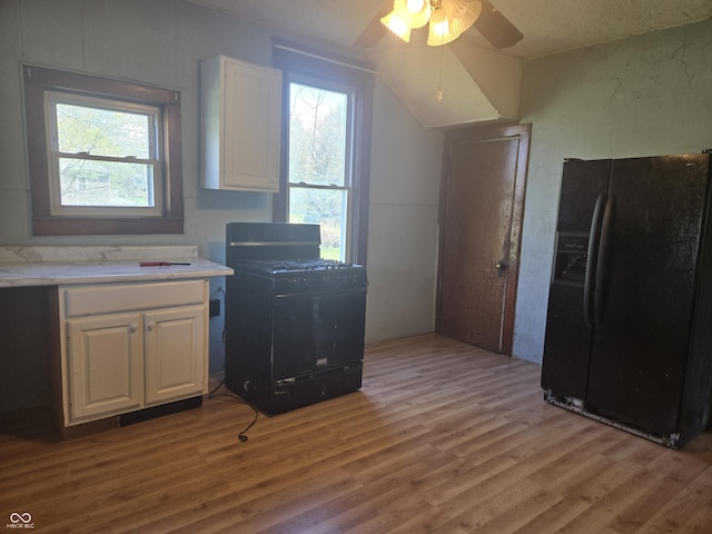 kitchen with white cabinets, black appliances, ceiling fan, and light wood finished floors