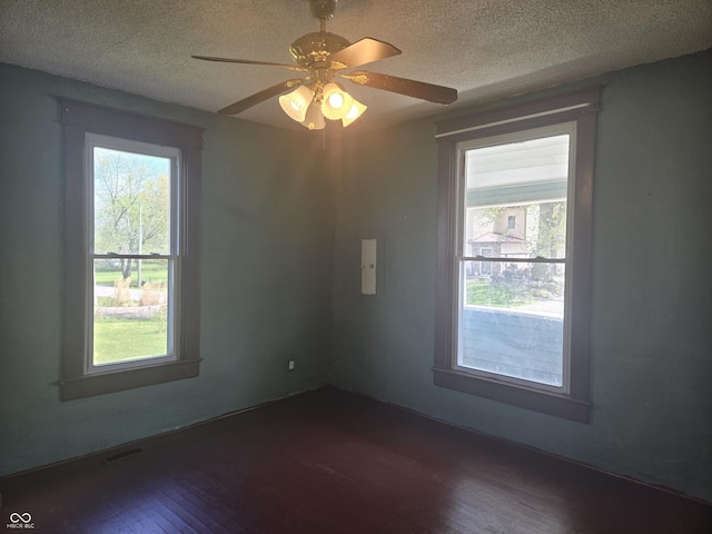 unfurnished room featuring dark wood-style floors, a textured ceiling, and a ceiling fan