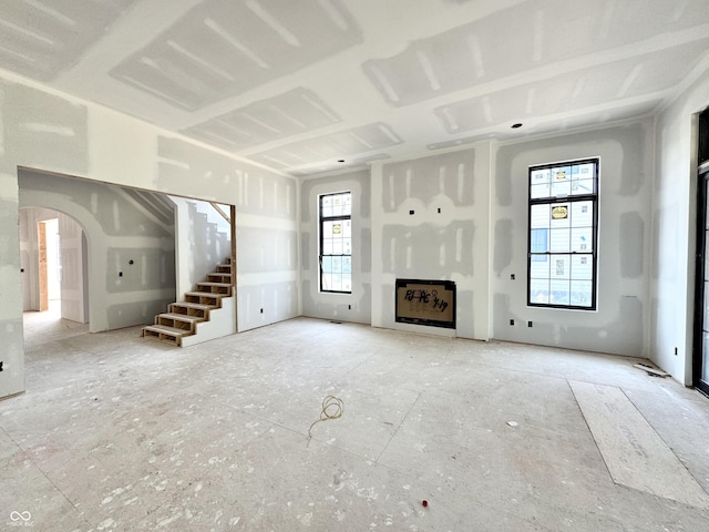 20598 Chatham Creek Dr, Westfield, IN 46074 - unfurnished living room featuring stairs, arched walkways, and a fireplace