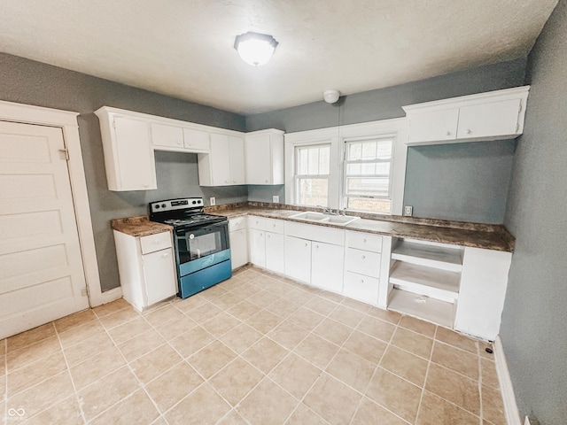kitchen featuring white cabinets, light tile patterned floors, stainless steel electric stove, and a sink