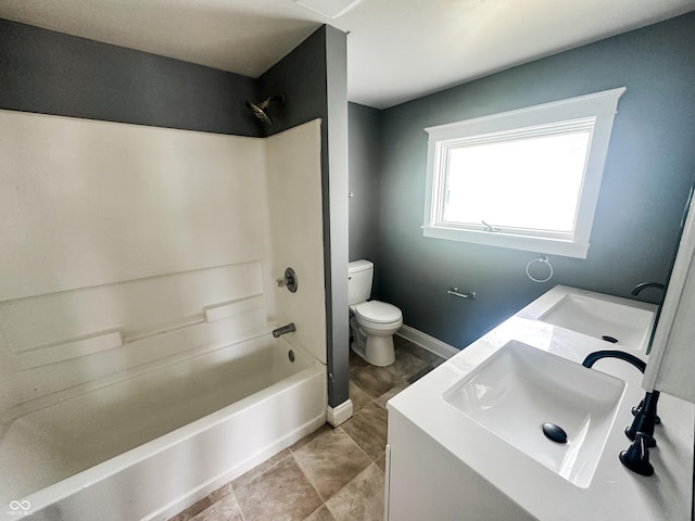 bathroom featuring a sink, bathing tub / shower combination, toilet, and double vanity