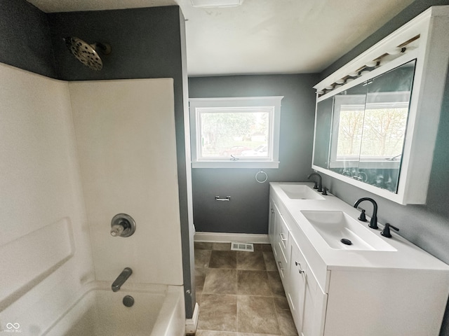 bathroom with double vanity, visible vents, washtub / shower combination, and a sink