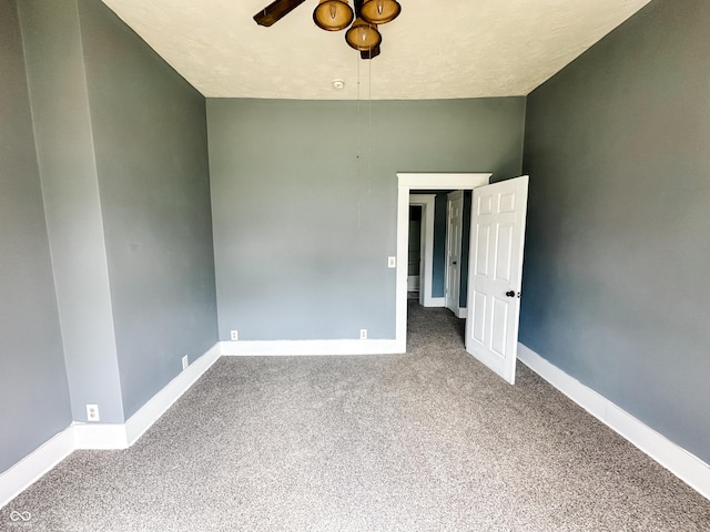carpeted spare room with baseboards and ceiling fan
