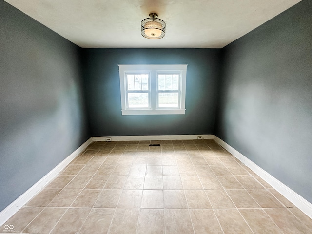 spare room featuring light tile patterned floors, baseboards, and visible vents