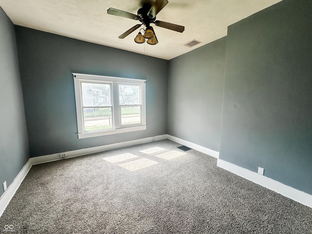 carpeted spare room with a ceiling fan, baseboards, and visible vents