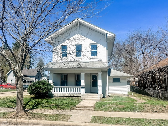 view of front of property featuring covered porch, fence, and a front lawn