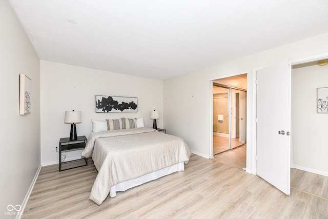 bedroom with light wood finished floors and baseboards