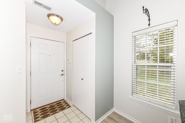 entrance foyer with light tile patterned floors, baseboards, and visible vents