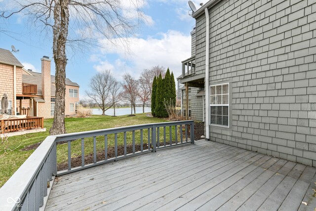 deck with a water view and a yard