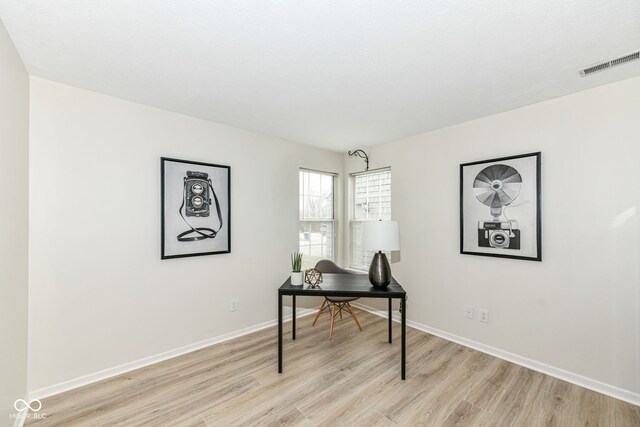 office with baseboards, visible vents, and light wood-style flooring