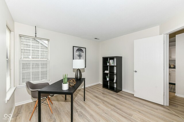 home office featuring baseboards and light wood-type flooring