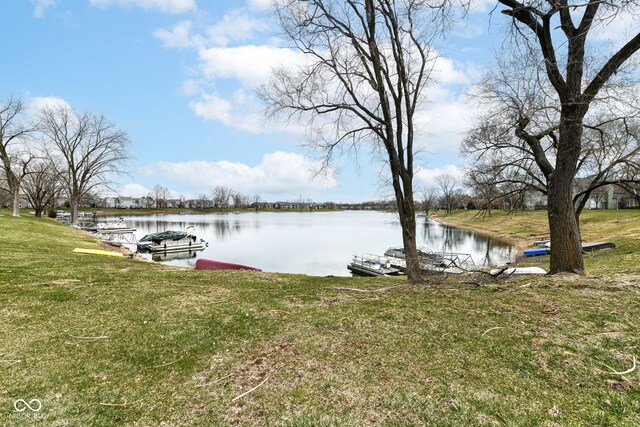 view of dock featuring a lawn and a water view