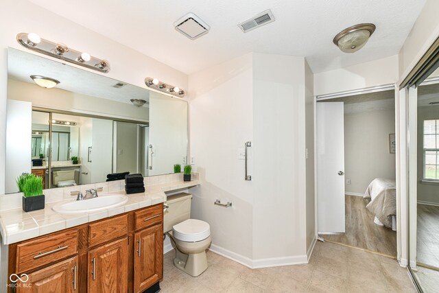 ensuite bathroom featuring tile patterned floors, visible vents, vanity, and ensuite bathroom