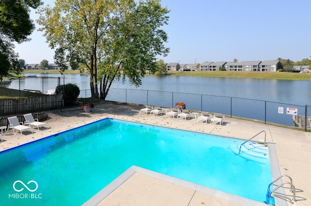 pool featuring a water view, fence, and a patio