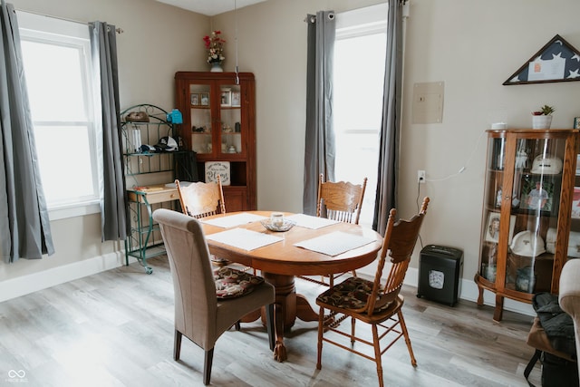 dining room with baseboards and light wood-style flooring