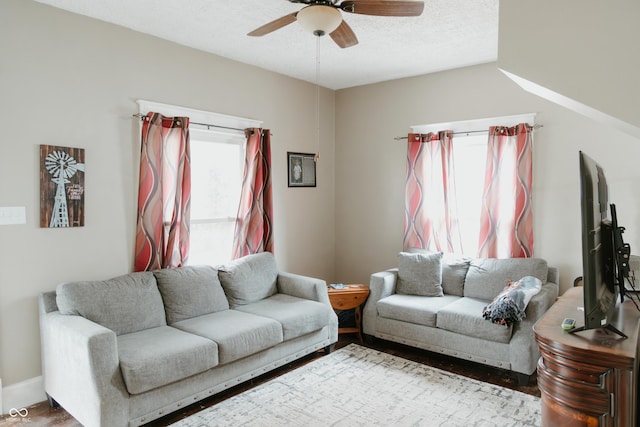 living room with a textured ceiling, wood finished floors, and a ceiling fan