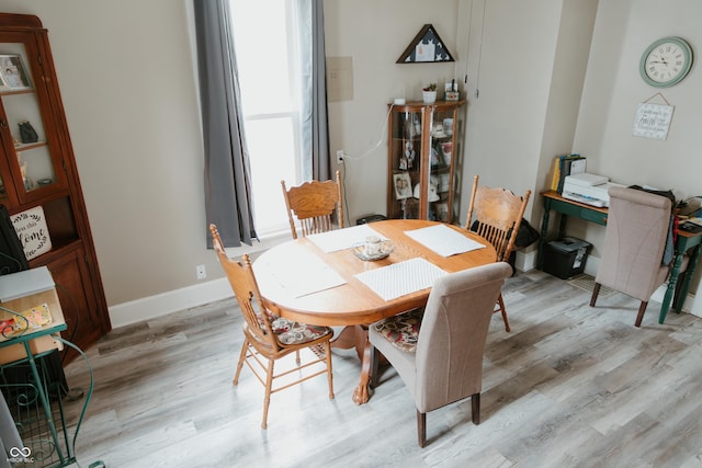 dining room with baseboards and light wood-type flooring