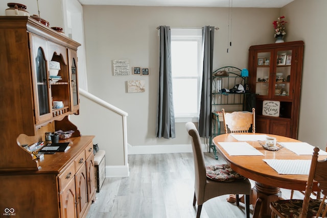 dining area featuring baseboards and light wood-style floors