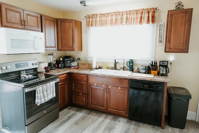 kitchen with a wealth of natural light, a sink, stainless steel range with electric stovetop, black dishwasher, and white microwave