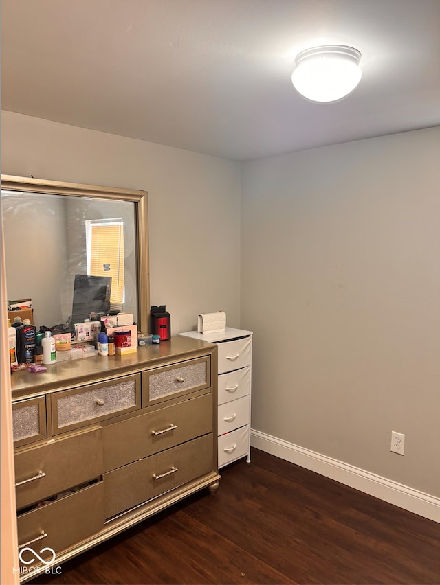 interior space featuring baseboards and dark wood-type flooring