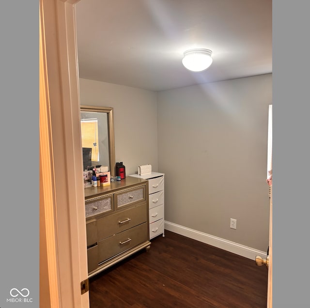 interior space featuring dark wood-style flooring and baseboards