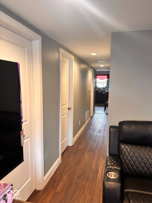 hall with baseboards, dark wood-style flooring, and visible vents