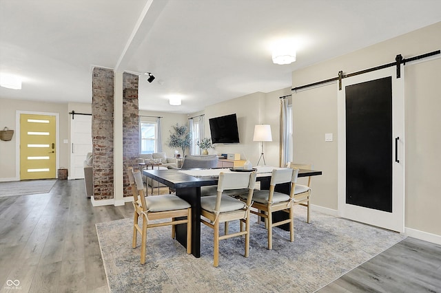 934 E Minnesota St, Indianapolis, IN 46203 - dining space featuring baseboards, a barn door, and light wood finished floors