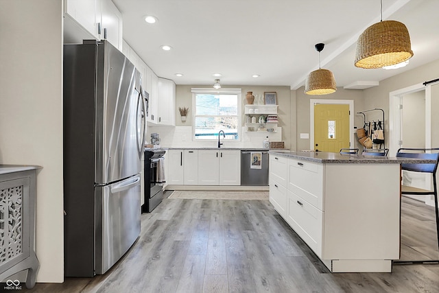 934 E Minnesota St, Indianapolis, IN 46203 - kitchen with white cabinets, stainless steel appliances, open shelves, light wood-type flooring, and hanging light fixtures