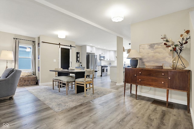 934 E Minnesota St, Indianapolis, IN 46203 - dining area featuring baseboards, a barn door, and light wood-style floors