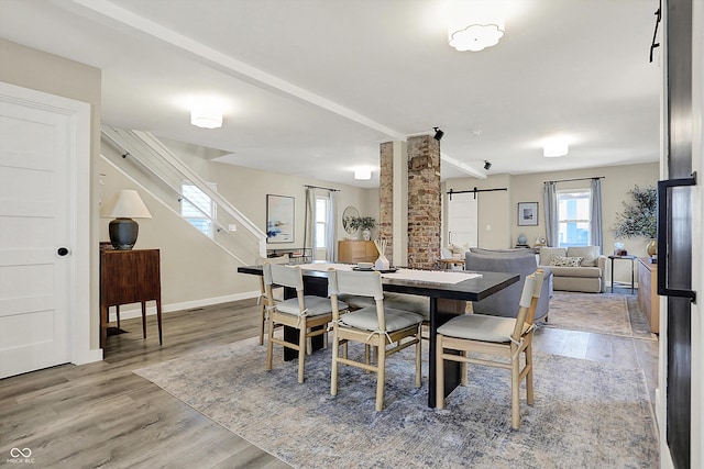 934 E Minnesota St, Indianapolis, IN 46203 - dining area with baseboards, a barn door, and wood finished floors