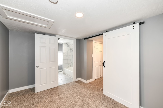 unfurnished bedroom with ensuite bathroom, baseboards, and light carpet